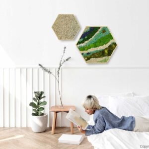 žena ležiaca na posteli a čítajúca knihu v bielej miestnosti so šesťhrannou stenou visiacou nad ňou, environmentálne umenie , machovy obraz, stabilizovany mach, machová stena, machová dekorácia